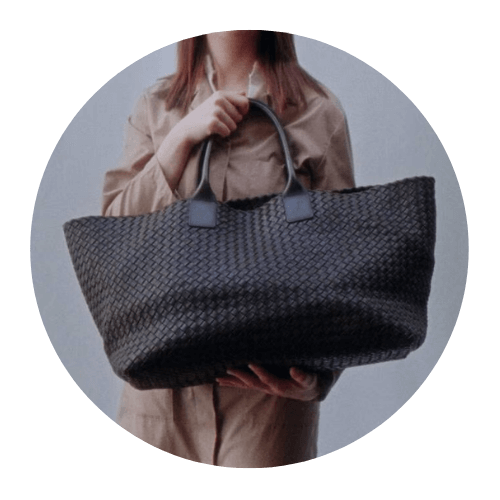 A person holding a large Bottega Veneta bag