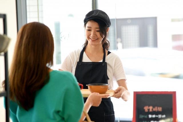 A female staff helping a customers with their food tray