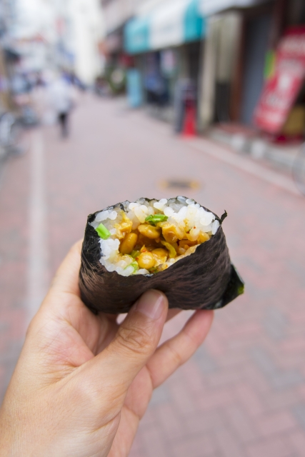 Close up rice ball wrapped with seaweed and filled with beans and green onion