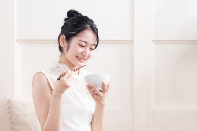 Female holding a bowl and chopsticks with her hands