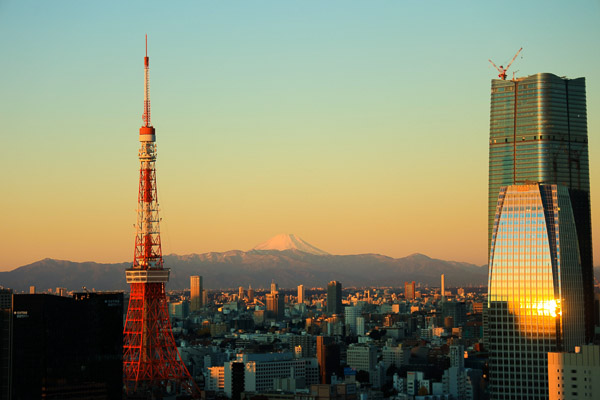 Tokyo city scape with Tokyo Tower in the foreground and Mount Fuji seen in the distance at sunset