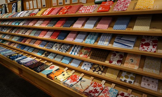 Dozens of tenugi towels nicely lined up on a shelf inside a store in Japan