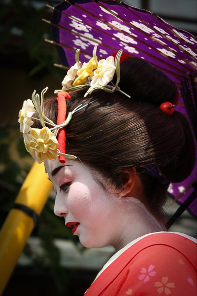 A close up of a Maiko from the side, revealing the edge of her wig.