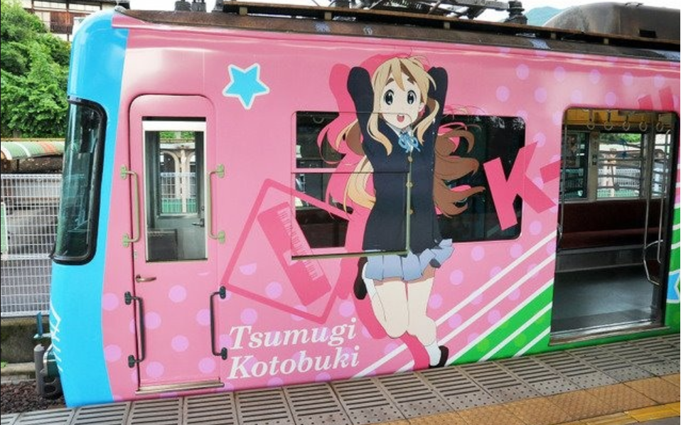 A trains decorated with a character from the anime K-On