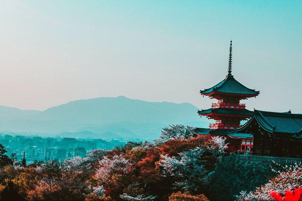 The five story pagoda at the entrance of Kiyomizudera in Kyoto, seen from inside the temple grounds with Kyoto city in the background