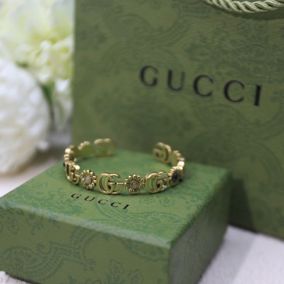 Gucci bangle with flower details and the brand's iconic GGs