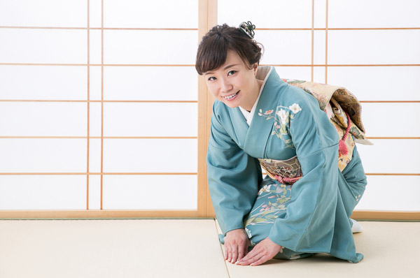 A Japanese woman in kimono kneeling on in a tatami room