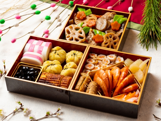 3 different boxes with common dishes served during New Year's in Japan