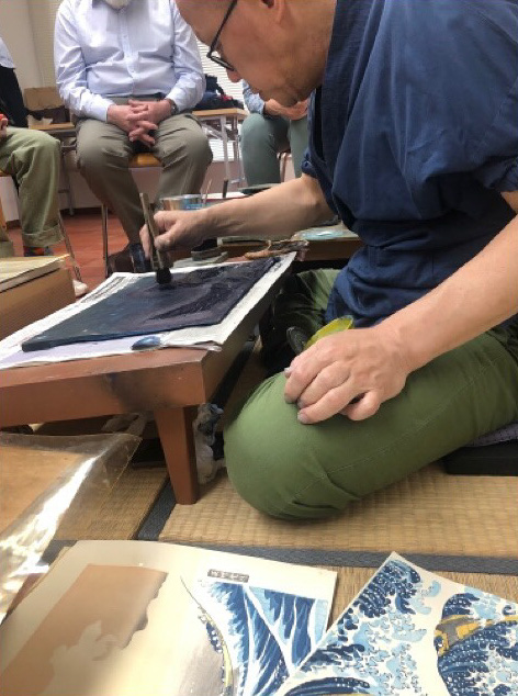 Man putting ink on a woodblock before printing