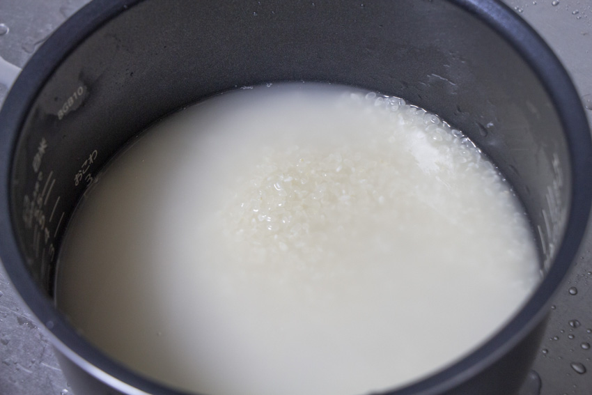 A pot filled with rice soaking in water.