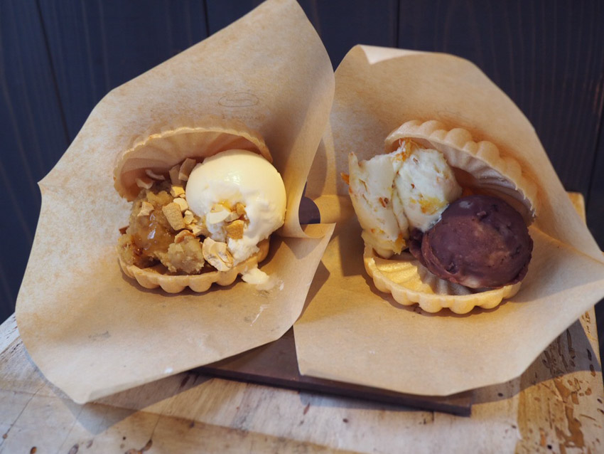Two monaka wafers with ice cream, nuts anko fillings in paper covers