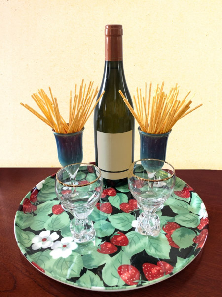 A bottle of red wine with Pretz in glasses on the sides