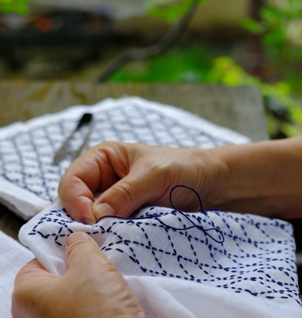 Image of someone embroidering a piece of cloth using the Japanese "Sashiko" technique 