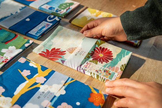 Close up image of a person picking up a nicely folded tenugi towel