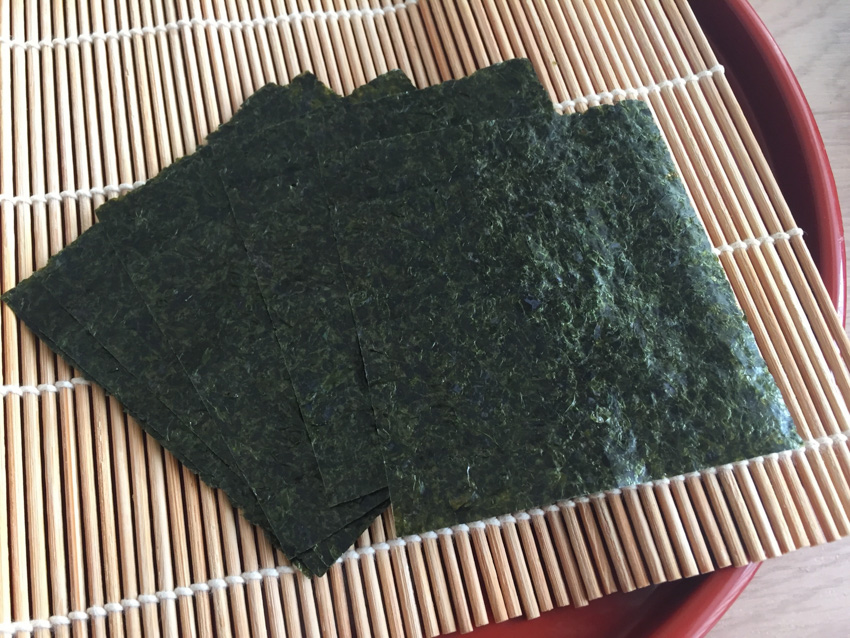 Big square sheets of nori for making sushi rolls on a bamboo sushi mat