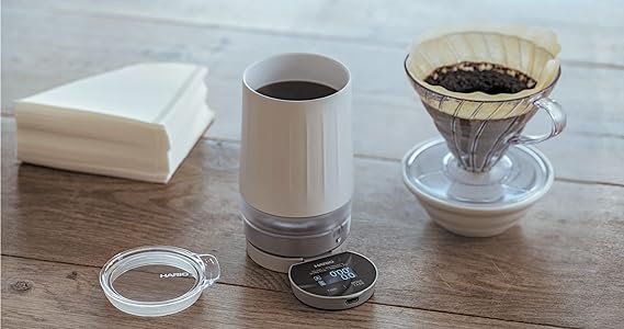 Hario Scale Mug near paper filter and a coffee dripper on top of a table