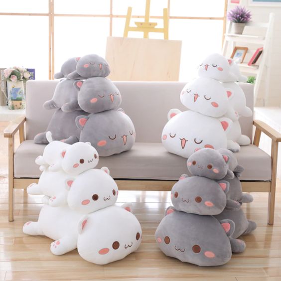 Cat shaped plushies in different sizes and facial expressions