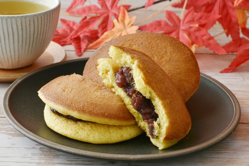 Dorayaki on a plate with autumn leaf decorations in the background.