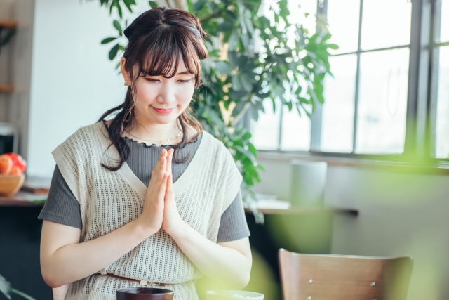 Female holding her hands together as a sign of respect before eating