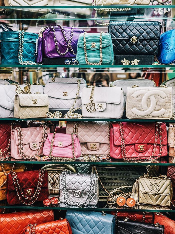 Shelf full of different colored Chanel bags 