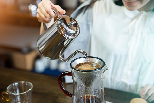 A coffee house staff preparing hot coffee by drip