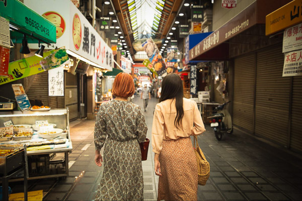 To women walking down an old style Japanese shopping street