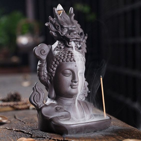 Incense holder in a shape of a Buddha's head with a dragon on top of it