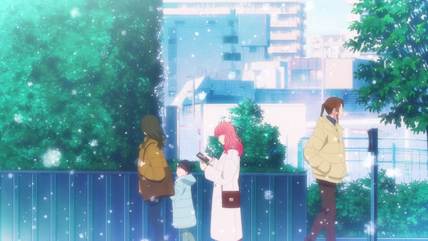 Yuki walking while looking at her phone in the city while it is snowing.