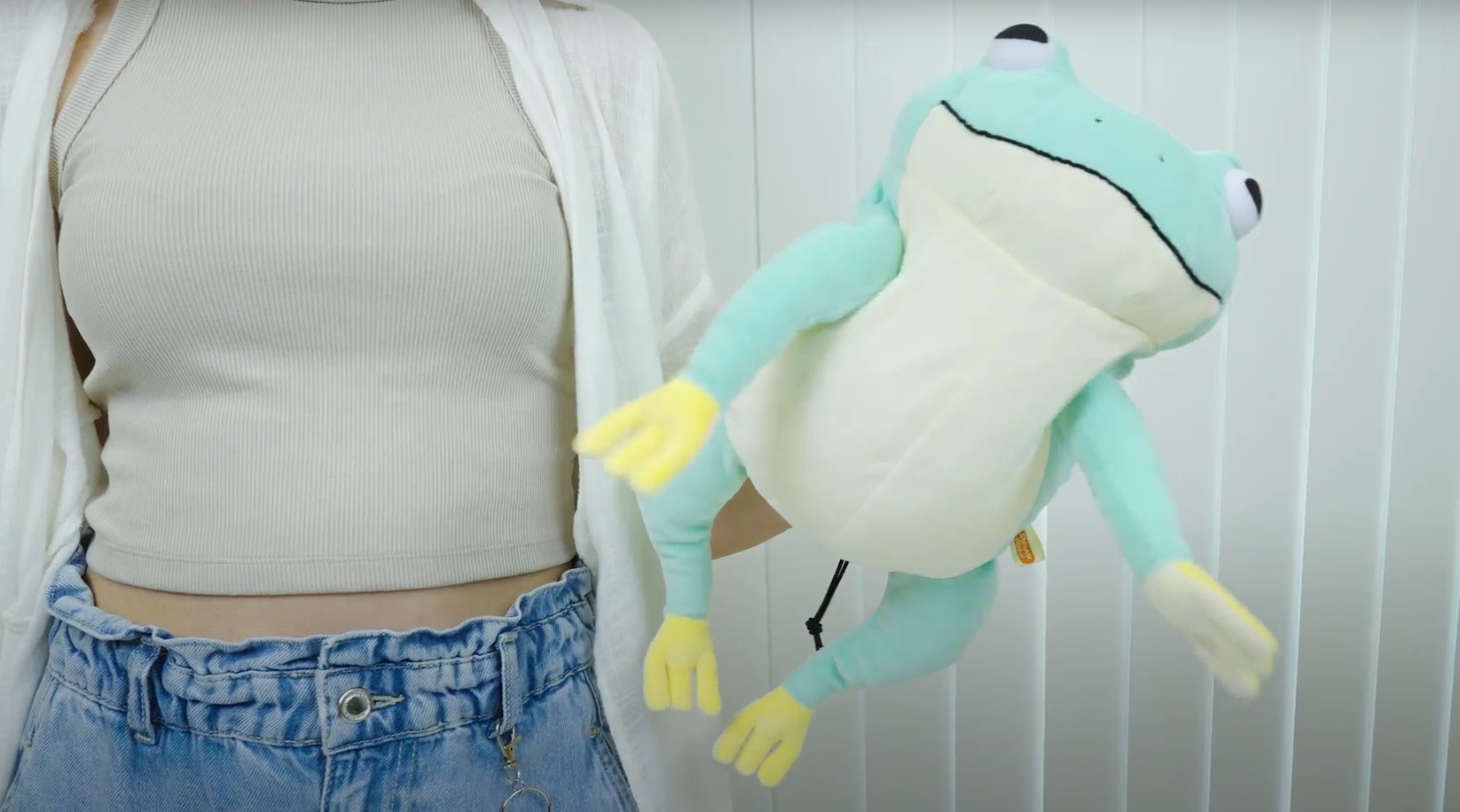 Female with hand inside light blue frog puppet 