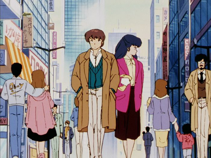 Godai and Kyoko walking down a city street with tall buildings around them