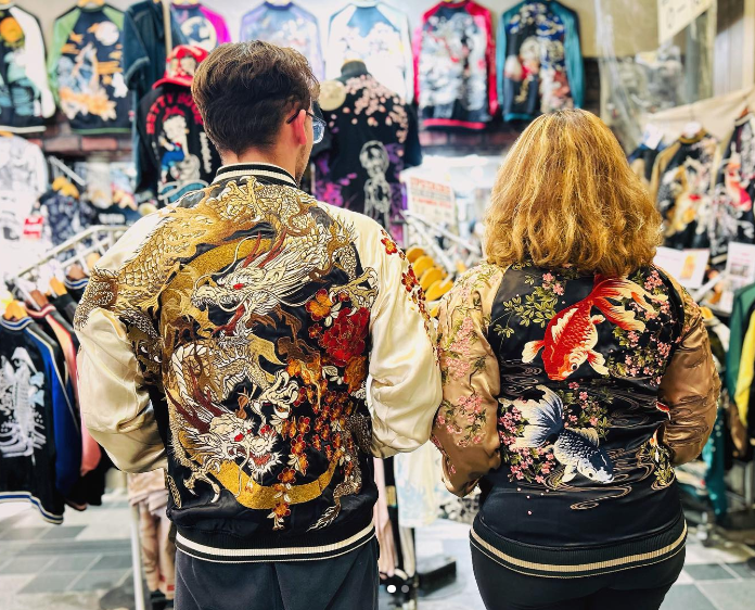 Two people standing up modeling the Sukajan jackets inside a store in Japan