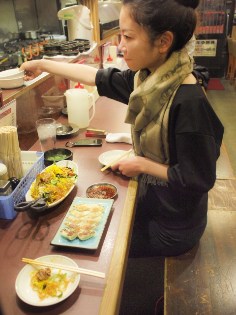 Female in a restaurant grabbing a plate on top of the counter  