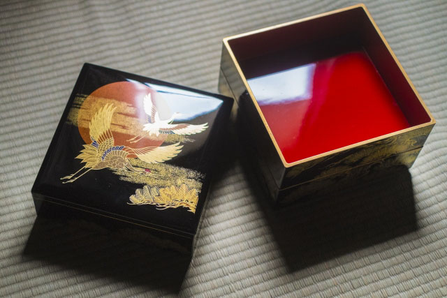 A black square box type lacquerware with crane bird ornaments.