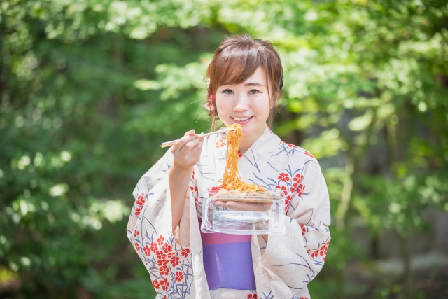 Japanese female holding a pack of noodles with chopsticks