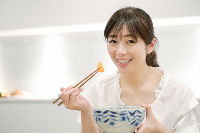 Woman eating with chopsticks