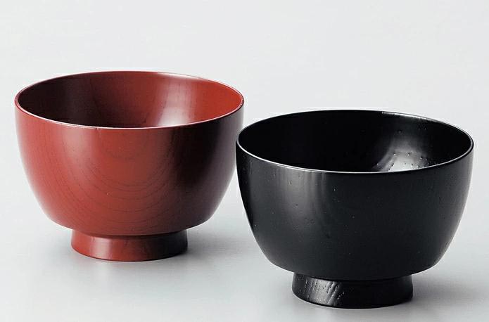 One red and one black wooden rice bowl.