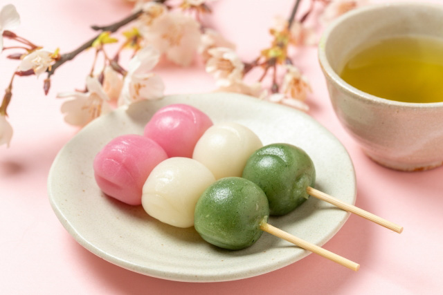 Two skewers with dango on a plate.
