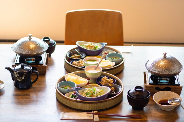 A table in a restaurant with two plates with different small dishes on it, a common practice in Japanese teishoku meals