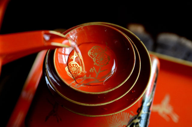 Sake being poured into a lacquerware saucer used for ceremonies