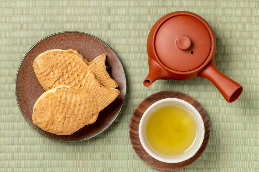 Taiyaki with a pot and cup of Japanese tea seen from above 