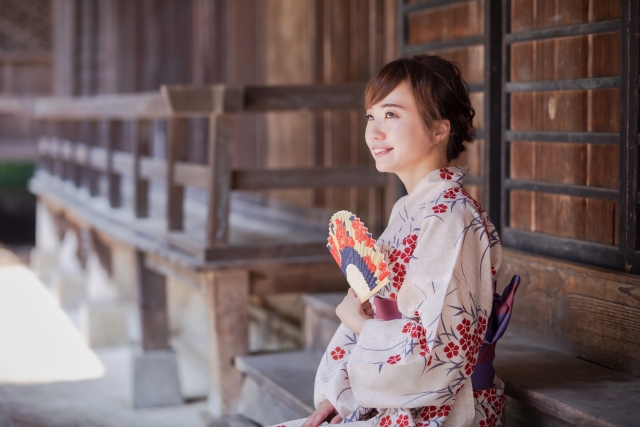 Woman wearing a Yukata, japanese summer kimono, holding a fan