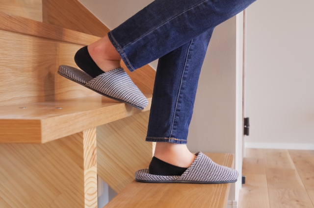 A person going down the stairs wearing slippers