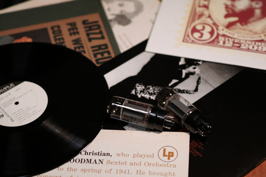 Vinyl records and a pair of vacuum tubes on a table