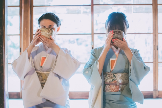 Two women drinking matcha from chawan bowls