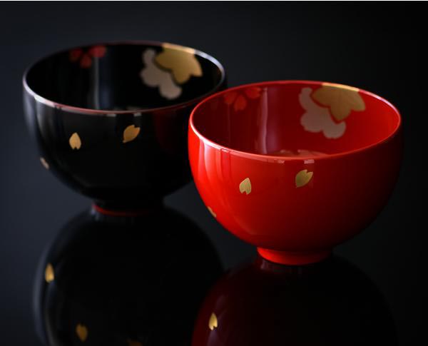 A black and a read miso bowl with small gold leaf patterns