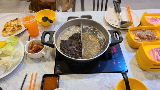 Shabu-shabu set prepared on a table with the half spilt pot set on an IH hot plate.