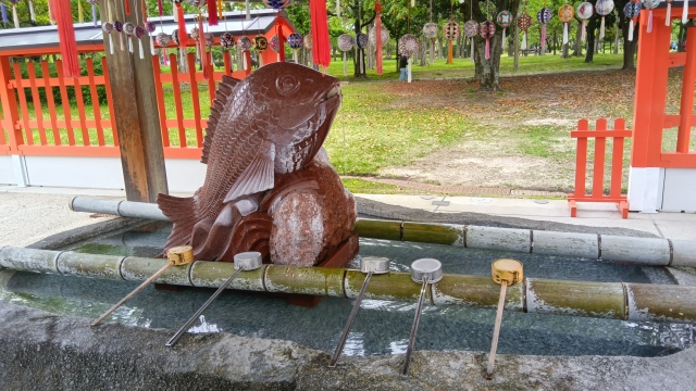 Fish statue at a temizuya, a place where you clean your hands and mouth before entering a shrine 