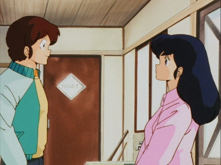 Godai and Kyoko standing looking at each other inside an entrance in a house.