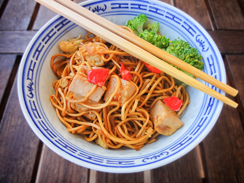 A plate of yakisoba with tofu in it. 