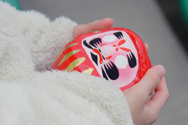 Person holding a daruma doll in their hands